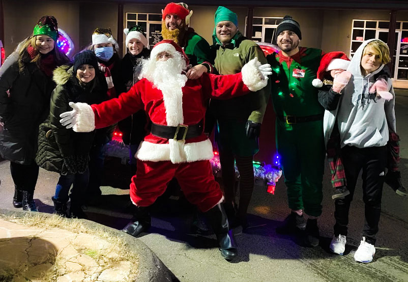 Santa and elves delivering gifts to a family